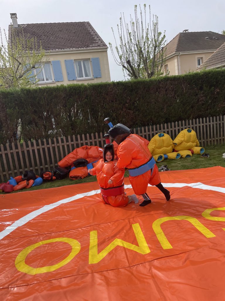 Participants en pleine action dans un combat de sumo en mousse, animation festive
