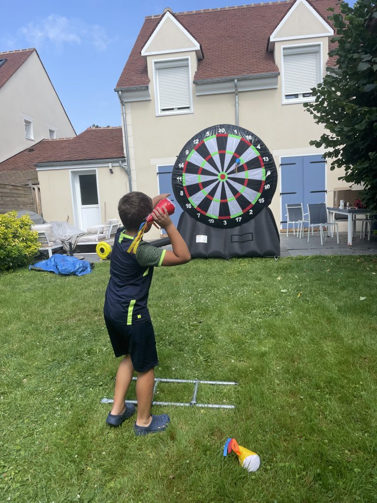 Participants s'affrontant pour viser la cible football géante lors d'une fête.