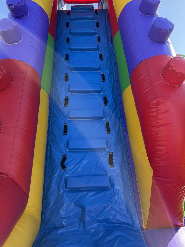 Enfant montant les marches d’une structure gonflable LEGO pour accéder au toboggan en toute sécurité