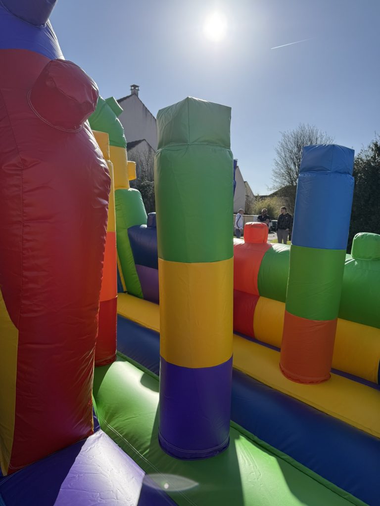 Enfants qui sautent et s’amusent dans la zone de jeu d’une structure gonflable LEGO lors d’un anniversaire