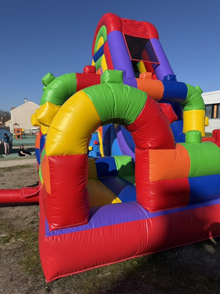 Entrée d’une structure gonflable LEGO avec ouverture sécurisée permettant aux enfants d’accéder à la zone de jeu